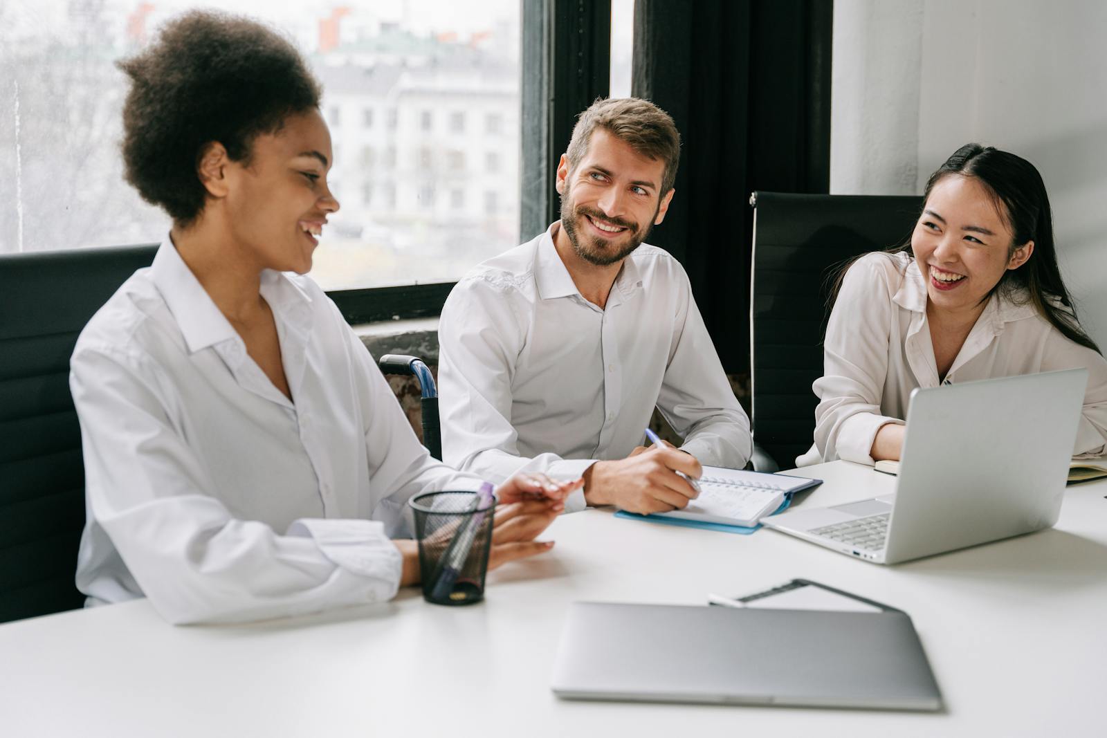 Three professionals in a warm, engaged team meeting around a conference table